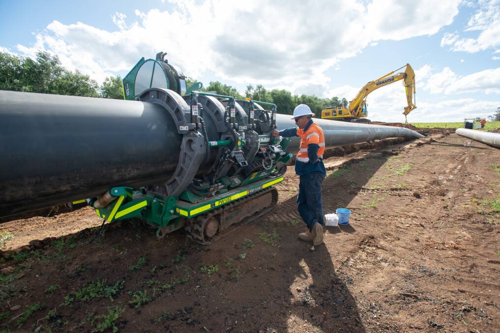 Dungowan pipeline segments being lowered into a trench near Calala. Picture by Peter Hardin