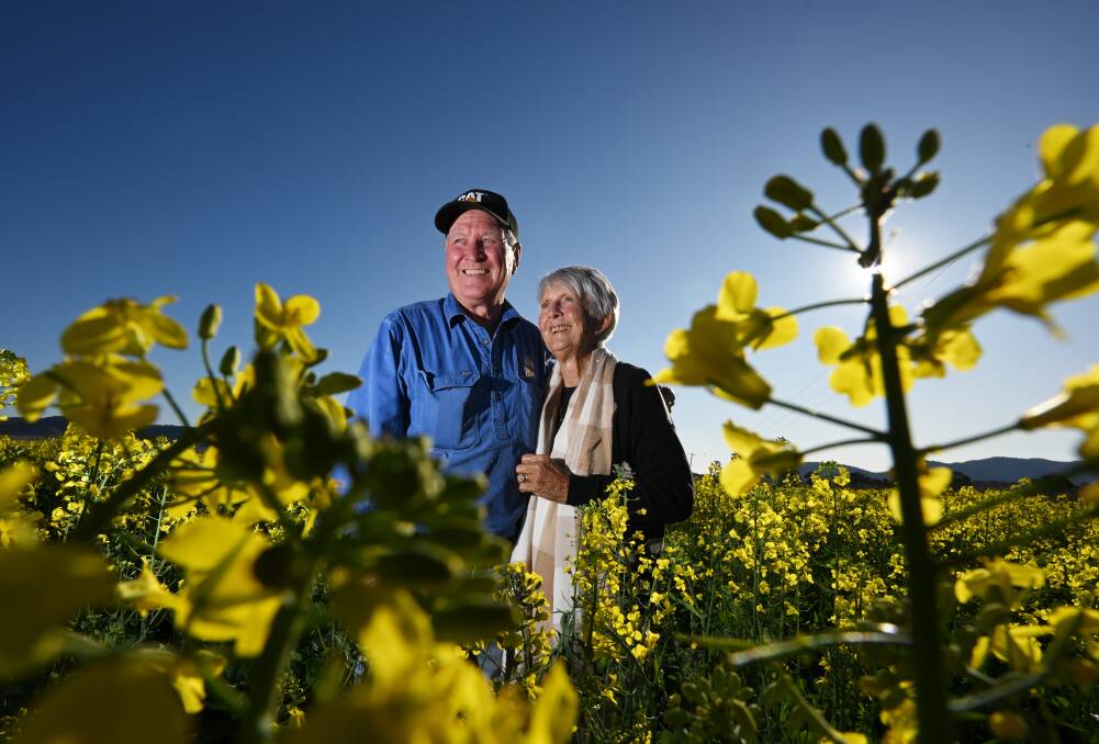Tony and Lyn Windsor stand in one of their blooming canola fields. Picture by Gareth Gardner.