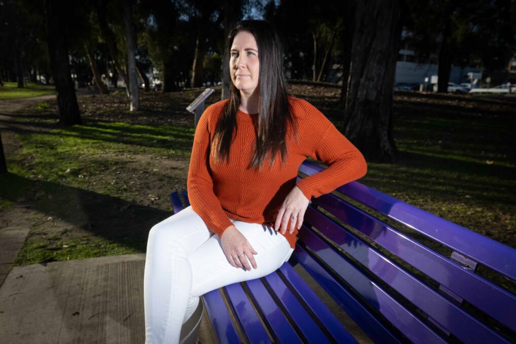 Rally organiser Tara Grant sits on the domestic violence purple bench in Bicentennial park. She says there needs to be more of a focus on domestic and sexual violence. Picture by Peter Hardin