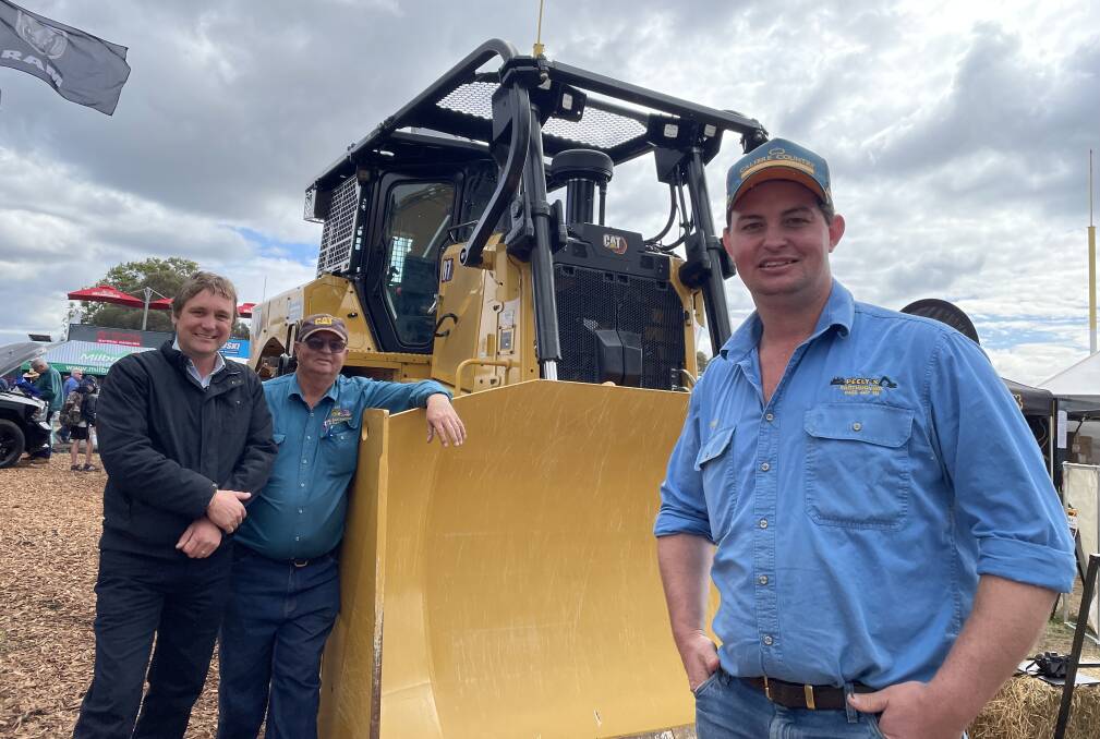 Aon AgQuip 2022 exhibitor Westrac machine sales representative for Tamworth and Moree, Tim Moore, with Warwick Peel and son Grant, who spent $940,000 buying a new Caterpillar D7.