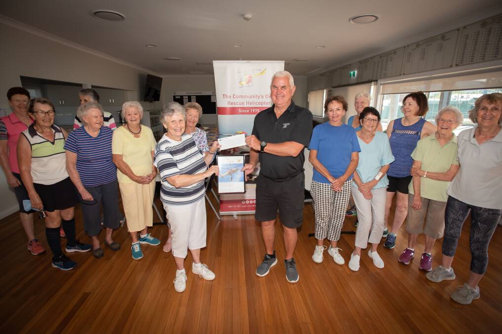 The tennis group meets twice a week to play, pictured here handing over $1000 to the Westpac Rescue Helicopter's Geoff Galbraith. Picture by Peter Hardin