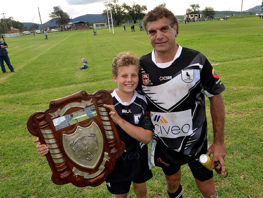 In his footsteps: Stuie Porter holds the Shield up with his son after the grand final and claimed that he will come out of retirement to play a season alongside his boy.