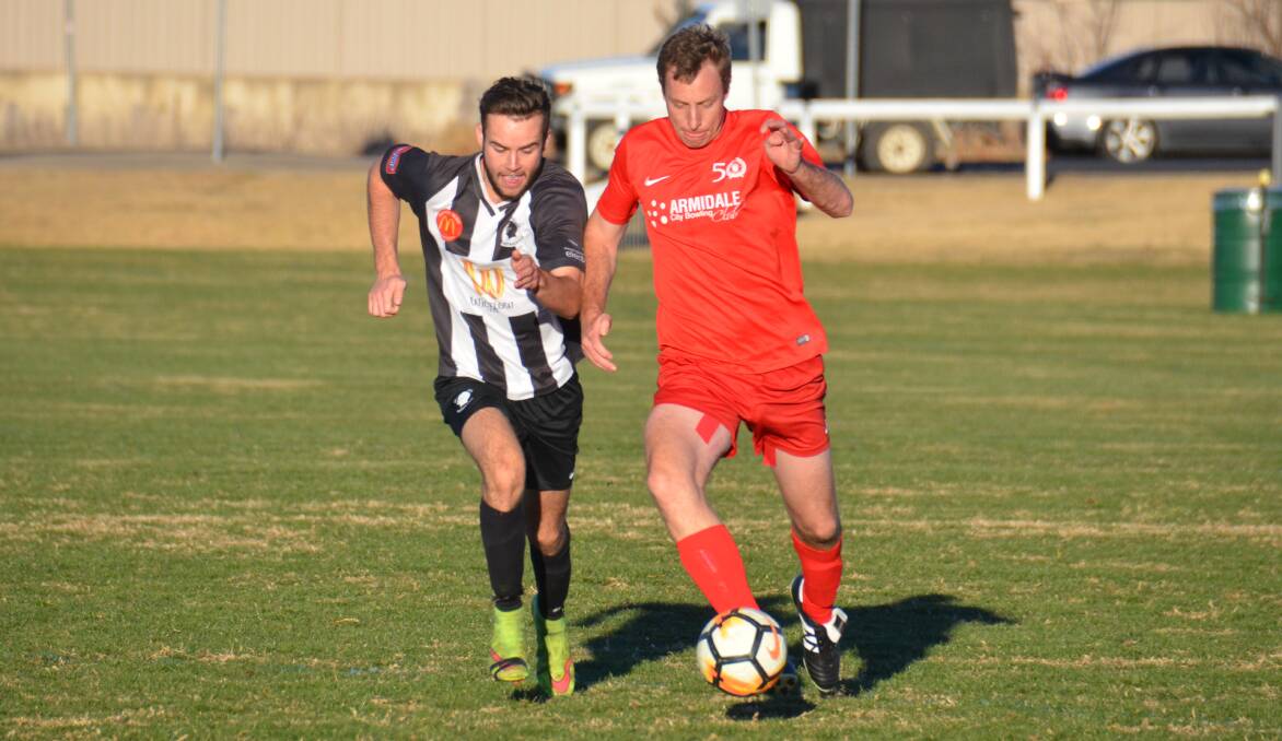 CLASH: Demon Knights' Reece Burton and Norths United's Tom Model battle for possession in Sunday's catch-up game. Demon Knights won the game 5-0.