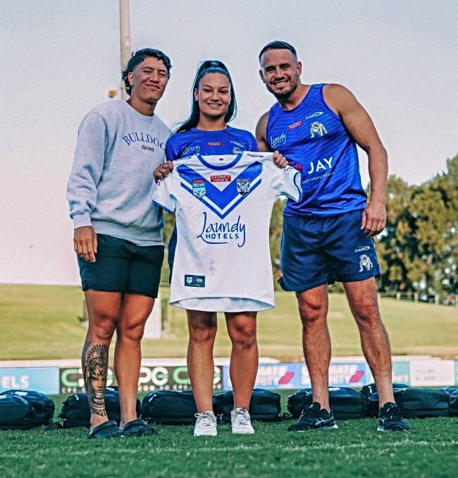 Charlotte Eather receives her Tarsha Gale Cup jersey from fellow Bulldogs Gayle Broughton and Josh Reynolds. Picture supplied 