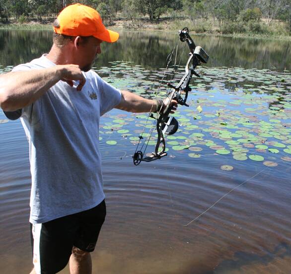 LONG BOW: Jason Flesch takes a shot at a big carp at Jingellic during an 18-month trial of bowfishing, the practice could be legalised in inland waters. Photo: CONTRIBUTED
