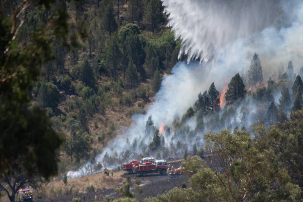 The fire burned through rugged terrain as a waterbombing chopper assisted. Pictures by Peter Hardin