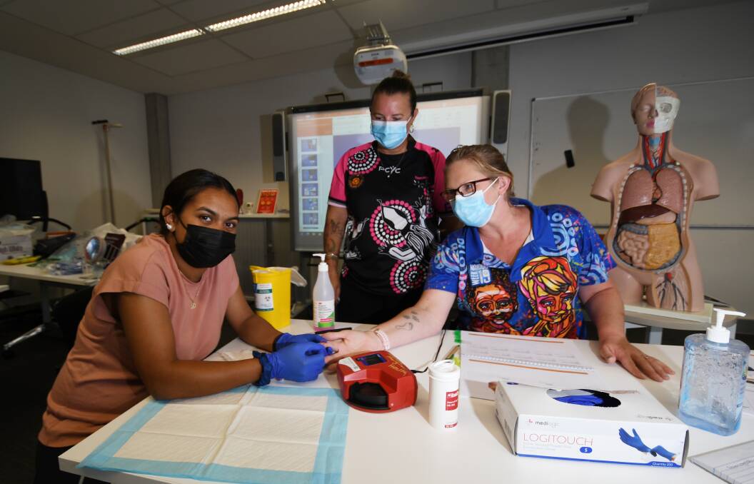 HIGH DEMAND: Kiara Smith, Vicki Gardner and Amelia Wlliams busy learning skills during the Aboriginal Health class at TAFE Tamworth. Photo: Gareth Gardner