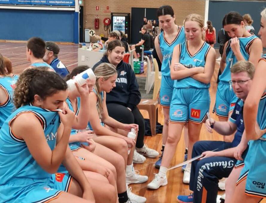 Intensity: The Tamworth Under 18s Girls get a pep talk from coach Scott Ward (right) during their game against the Central Coast Rebels. Photo: Tamworth Basketball Association Facebook.
