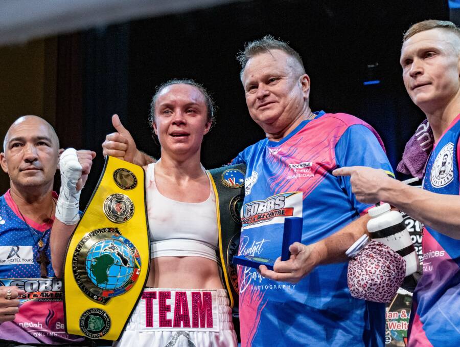 Ryan cherishes the team around her, including coach Dave Syphers (centre right) and husband and fellow pro boxer, Wade (right). 