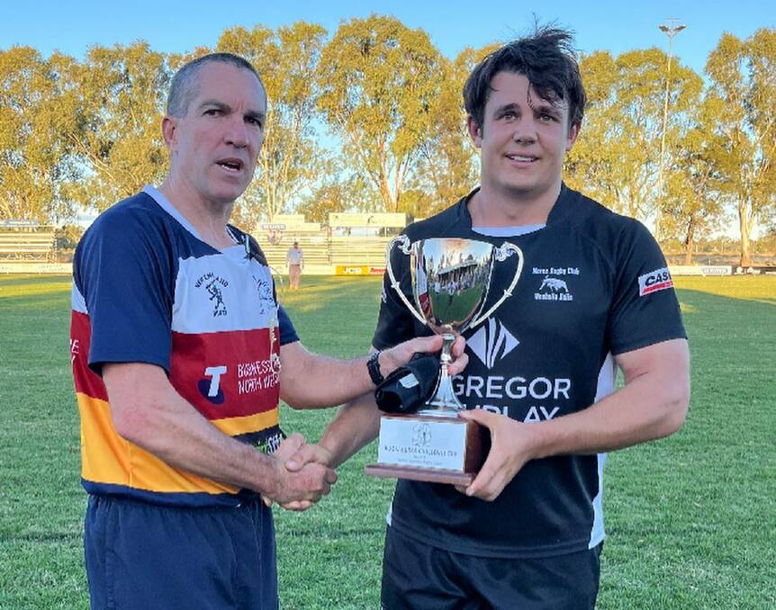 Moree captain Duncan Woods receives the Kookaburra Challenge Cup from Central North Referees Association member Jeremy Matthews.