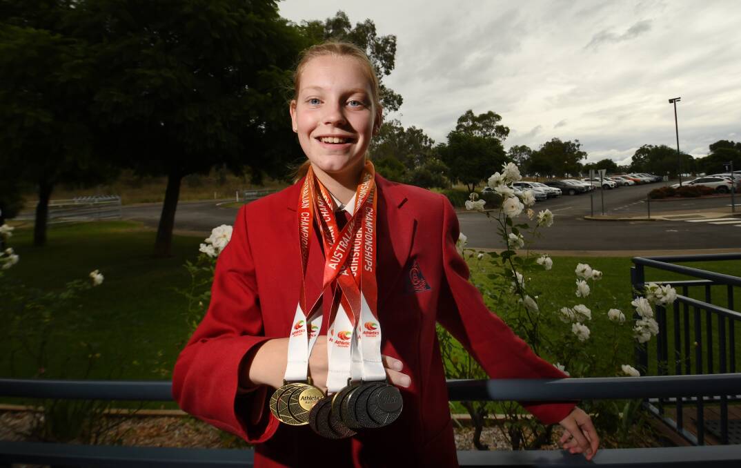 Golden glow: Abbie Peet with her medal haul from the Australian Track and Field Championships. Photo: Gareth Gardner 260422GGC01