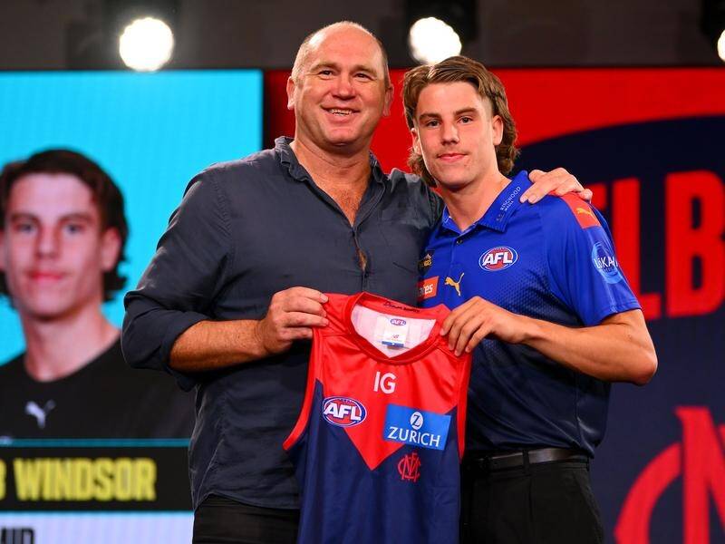 Caleb Windsor (right) is handed a guernsey by Melbourne legend David Neitz at the 2023 AFL draft. (Morgan Hancock/AAP PHOTOS)