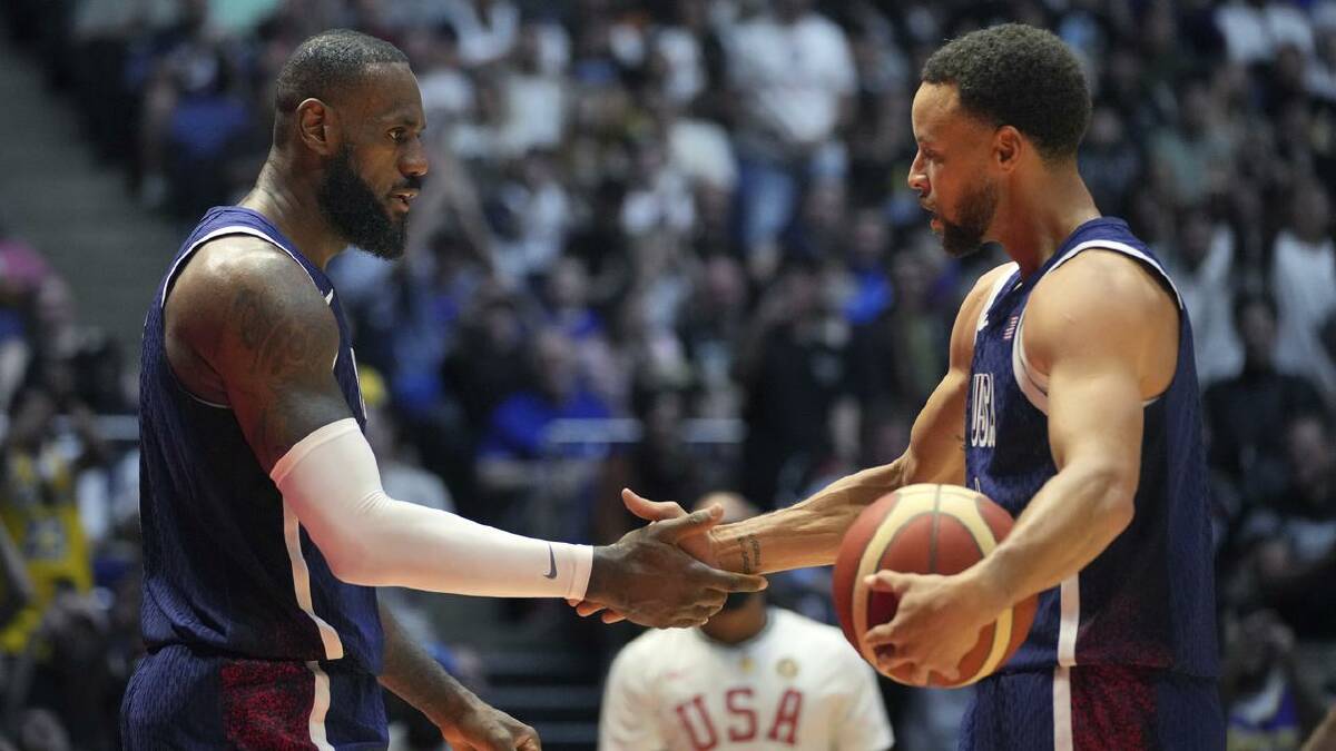 LeBron James and Stephen Curry celebrate after their narrow win in London. (AP PHOTO)