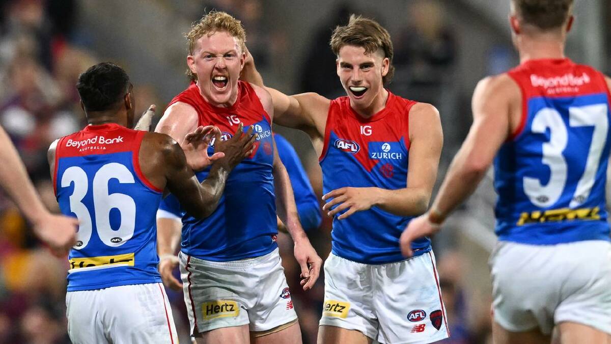 Teammates celebrate with Clayton Oliver after he kicked a goal against the Lions in round 16. (Darren England/AAP PHOTOS)