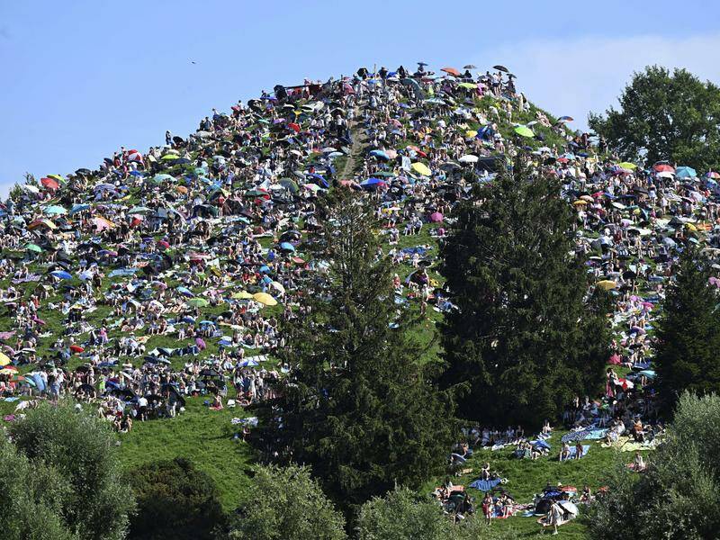 Taylor Swift fans sit on a hill outside Munich's Olympiastadion during the Eras concert. Photo: AP PHOTO