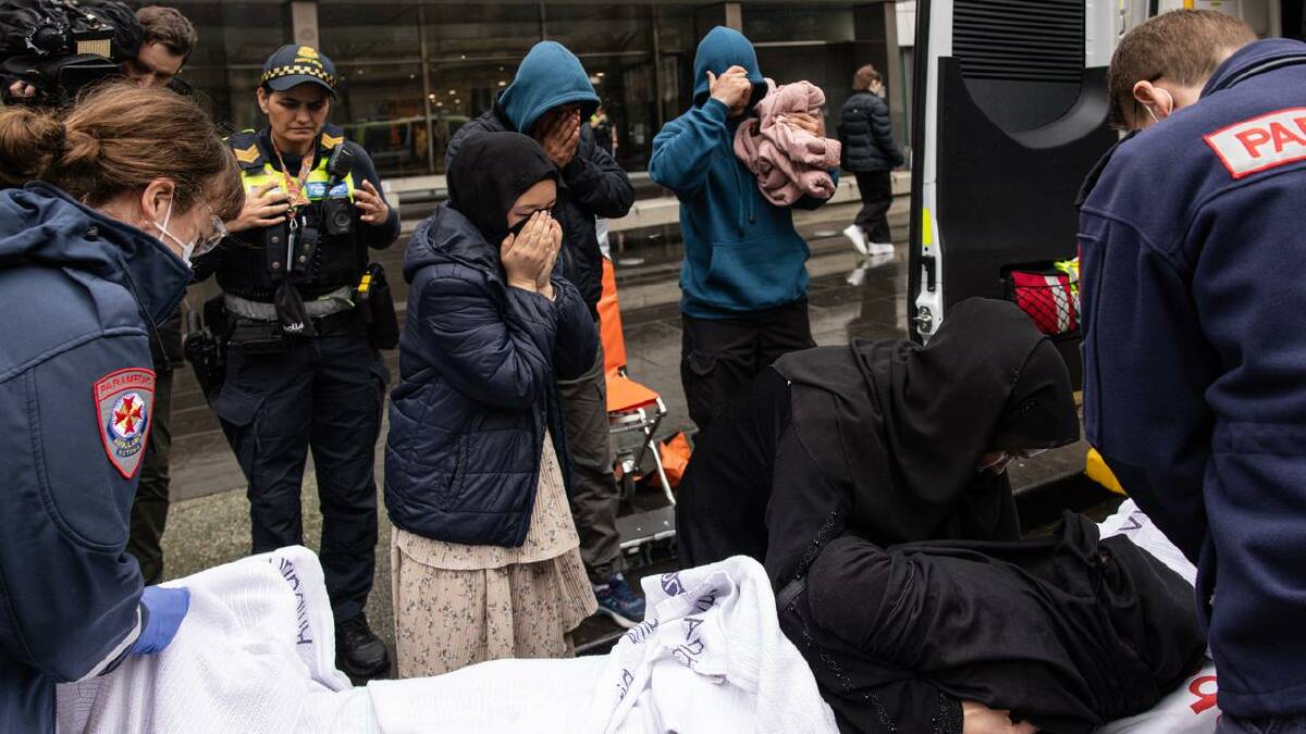 One of Sakina Muhammad Jan's supporters was taken to hospital after collapsing. (Diego Fedele/AAP PHOTOS)