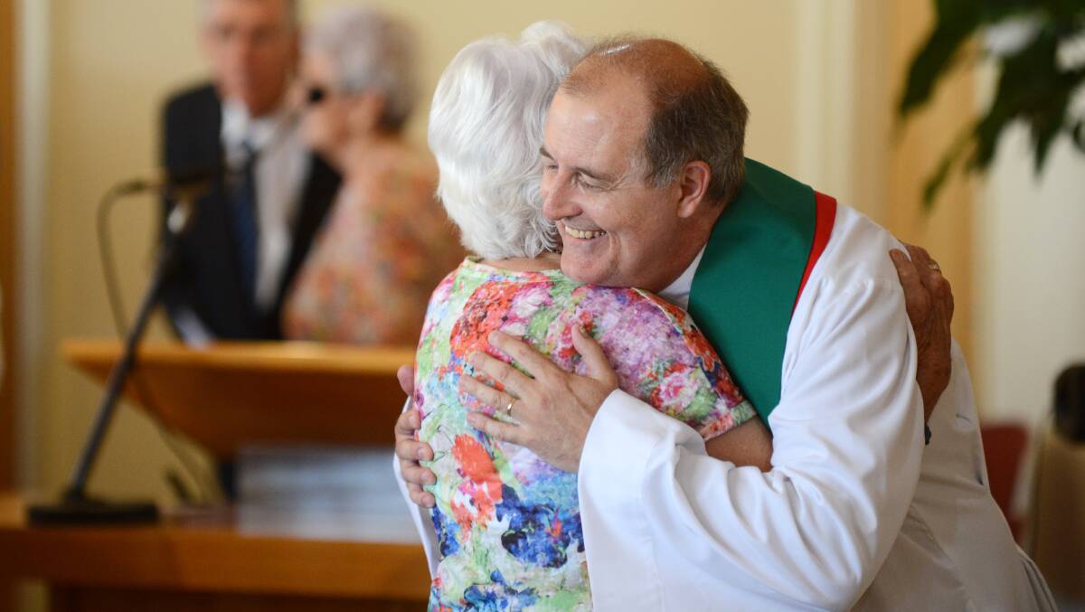 WELL DONE: Reverend Grant Atkins is congratulated by a congregation member at Southside Uniting Church. Photo: Barry Smith 221114BSB05