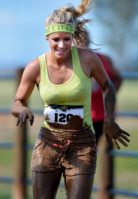 A runner makes her way through the obstacle course in the Suck it up Buttercup mud run in November. 301112BSA013