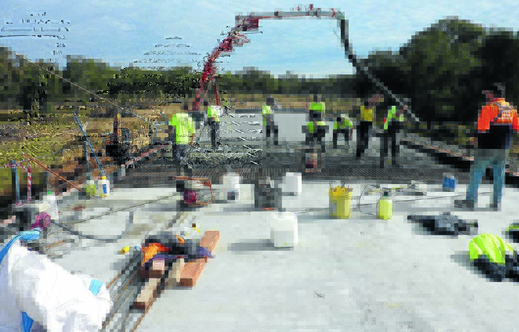 CEMENTING SUCCESS: Construction workers make the final pour for the new Emu Crossing Bridge deck.