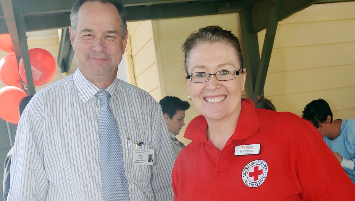 FAREWELL AND THANKS: Tamworth hospital general manager Brad Hansen gets things cooking at the barbecue with Sandee Thompson, community relations officer at the Tamworth Blood Donor Centre, on Tuesday Photo: Geoff O'Neill 280812GOC01